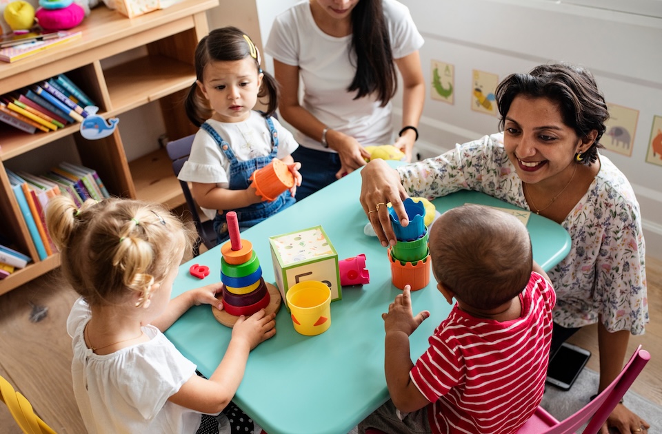 Teacher with kids around table in classroom